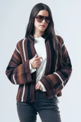 Cardigan de tejido de punto con diseño a rayas horizontales en tonos marrones, negros y blancos. Presenta un corte relajado, cuello alto y mangas largas amplias.