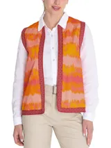Chaleco sin mangas estilo boho, con estampado de ondas en tonos naranja, rosado y amarillo. Presenta bordes con detalles geométricos en color bordó y cierre frontal abierto.