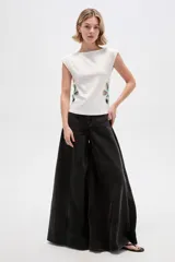 Remera de poliéster color blanco, de corte ajustado, con cuello bote, mangas sisa y detalles de aberturas (cut-out) en los costados con apliques florales en tono celeste.