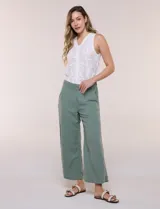 Pantalón crop de lino y rayón, con diseño wide leg de corte holgado, estampado tropical de hojas en tonos verde, azul y marrón sobre fondo blanco. Cuenta con pretina trasera elastizada y bolsillos delanteros.