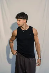 Musculosa negra de tejido morley, ajustada al cuerpo, con un pequeño bordado en color verde en el pecho.