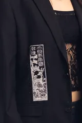 Blazer negro con parches y estampado en serigrafía.