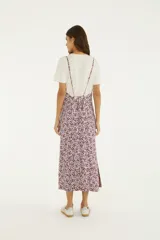 Vestido midi fluido de corte recto, con tirantes finos y diseño estampado floral en tonos bordó y lila.