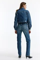 Jean de tiro alto y pierna recta confeccionado en denim de algodón con un leve porcentaje de stretch, de cinco bolsillos y diseño clásico en color azul con efecto deslavado.