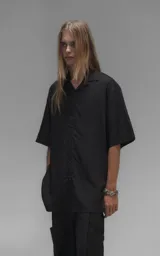 Camisa de manga corta con calce oversize, confeccionada en tejido de lyocell, con cuello clásico y cierre frontal de botones.