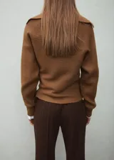 Sweater de punto color marrón, con cuello polo y escote en V, de manga larga y calce holgado.