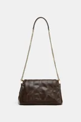 Bolso bandolera de hombro en color marrón, con diseño acolchado de costuras verticales. Cuenta con una cadena metálica dorada y un asa de mano superior. El cierre principal es mediante botón imantado.