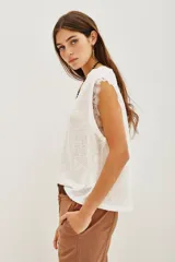 Musculosa blanca de lino con cuello redondo y detalle de encaje en las mangas.
