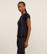 Remera deportiva negra de microfibra con cuello redondo, manga corta y detalles de raya contrastante en los laterales.