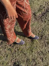 Zapato guillermina de cuero azul con ribete amarillo y hebilla plateada.