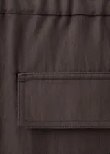 Pantalón marrón de corte recto y tiro medio, confeccionado en mezcla de lyocell y viscosa. Cuenta con bolsillos laterales y bolsillos traseros con solapa.