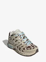 Championes Adidas Adistar Control 5 con diseño de estampado animal print tipo vaca en tonos marrón y blanco. Presenta detalles en color beige, acentos en celeste en los cordones y la entresuela, y estructura reforzada con paneles laterales.