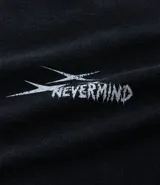 Remera de algodón con efecto desteñido, corte boxy, cuello redondo y manga corta. Presenta un estampado de lettering blanco en el pecho con el texto "Nevermind" y un diseño gráfico estilizado.