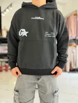 Canguro oversize gris con capucha y gran estampado gráfico trasero en tono más oscuro.