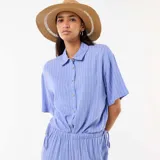 Camisa azul de manga corta con diseño de rayas verticales blancas, cuello camisero y cierre frontal con botones.