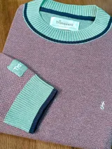 Sweater de hilo color ladrillo con cuello redondo, puños y ruedo en tejido de punto acanalado color verde agua con detalle de línea azul marino.