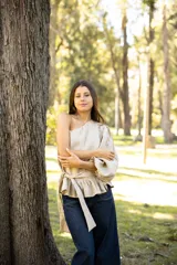 Blusa de lino con diseño asimétrico de un solo hombro, manga larga abullonada y detalle de lazo lateral en la cintura con volado.