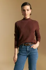 Polera de tejido acanalado color bordó, con cuello alto y diseño geométrico en relieve. Presenta mangas largas y un calce ajustado al cuerpo.