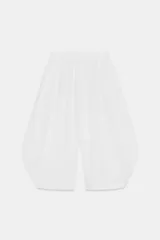 Pantalón blanco de tiro alto con cintura elástica ajustable mediante lazada interior. Presenta bolsillos laterales y un bajo con mucho volumen.