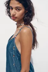 Vestido midi de denim azul, con escote en pico y tirantes finos.