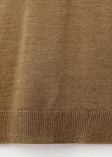 Sweater de punto fino color mostaza, con cuello alto y mangas largas de diseño recto.