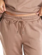 Jogger deportivo de corte holgado, con cintura elástica y lazo de ajuste, bolsillos laterales y puños elásticos en los tobillos.