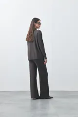 Pantalón de punto de corte relajado, con pierna recta y caída fluida. Presenta cintura con cordón ajustable y diseño minimalista.