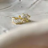 Par de aros tipo huggies dorados con circonias blancas engarzadas.