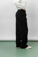 Pantalón de corte relajado y pierna recta, confeccionado en tejido tipo corderoy liviano. Presenta cintura elastizada con cordón ajustable y diseño de silueta amplia.
