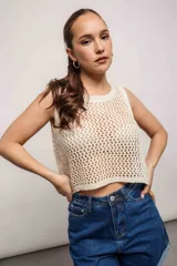 Blusa de poliéster y elastano color crudo, de tejido calado con transparencias y corte crop.