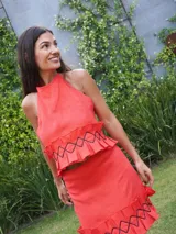 Top de lino color coral con cuello halter y detalle de volados en el ruedo con cordones negros cruzados.