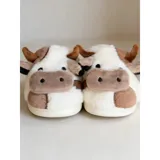Pantuflas de peluche con diseño de vaca, confeccionadas en piel sintética suave. Cuentan con suela de goma antideslizante y diseño abierto en el talón.