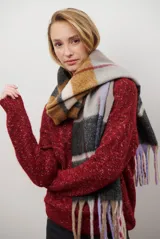 Buzo de punto color gris claro con motas oscuras, escote en V y mangas largas.