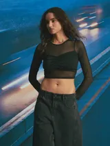 Top de manga larga confeccionado en tul transparente con un diseño superpuesto que incluye un corpiño tipo bustier con fruncido central.