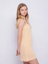 Vestido corto sin mangas de tela texturada con tirantes anchos y estampado a cuadros en blanco y negro.