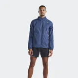 Campera cortavientos 2XU modelo Aero, color azul, confeccionada en tejido ripstop semitransparente. Cuenta con cierre frontal, capucha y bolsillos con cremallera.