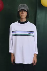 Remera de manga larga blanca con cuello alto en color azul. Presenta franjas horizontales de colores en el pecho y el logo de la marca estampado.