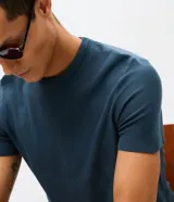 Remera masculina de tricot liso color beige, con corte slim, cuello redondo y mangas cortas.