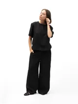 Remera negra de lino con mangas cortas y corte holgado. Tiene botones en la espalda.