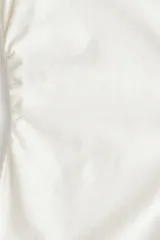 Top de manga larga confeccionado en punto de algodón, con cuello redondo, hombros caídos y detalle de frunces laterales que crean un efecto drapeado, finalizando en un bajo acampanado.