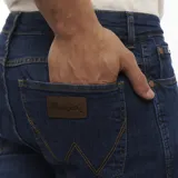 Jean Wrangler de corte ajustado, color azul oscuro, con bolsillos delanteros y traseros.
