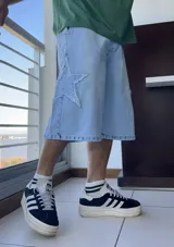 Bermuda de jean celeste, corte ancho y largo a la rodilla, con aplique de estrella en el lateral.