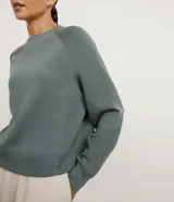Buzo de corte regular confeccionado en modal, con cuello redondo, mangas largas y costuras decorativas visibles. Presenta un diseño minimalista y versátil.