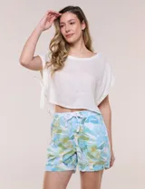 Short de lino con silueta relajada, estampado en tonos azules y tierra sobre fondo blanco. Posee cintura elastizada con cordón ajustable, bolsillos laterales y dobladillo en las piernas.