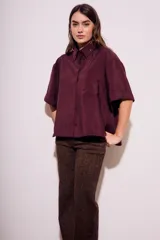 Camisa oversize color borgoña de mangas cortas con puños doblados y bolsillo en el pecho.