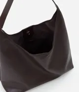 Cartera hobo grande de poliuretano color verde militar, con diseño slouchy, base estructurada y una única asa larga para llevar al hombro. Cuenta con cierre de botón a presión y amplio compartimento interior.