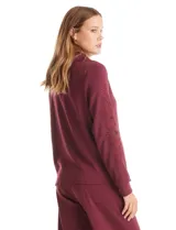 Campera bordó de modal con cuello solapa, cierre frontal con botones metálicos y bolsillos laterales. Presenta mangas largas con detalles labrados en los antebrazos y puños ajustados.