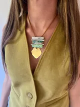 Collar con cordón de cuero marrón, con colgante de piezas rectangulares de nácar verde y pieza inferior de bronce en forma de escudo.