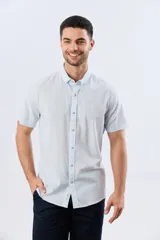 Camisa de manga corta confeccionada en mezcla de lino y algodón, con diseño de rayas verticales en tonos celeste y blanco. Cuenta con cuello camisero, botonadura frontal y bordado sutil en el pecho.