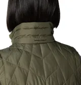 Chaleco acolchado Columbia color verde oliva, con tecnología termorreflectante Omni-Heat y tratamiento repelente Omni-Shield. Presenta cierre frontal de dos vías, bolsillos laterales con cremallera, bolsillo interior de seguridad y cuello forrado en felpa.